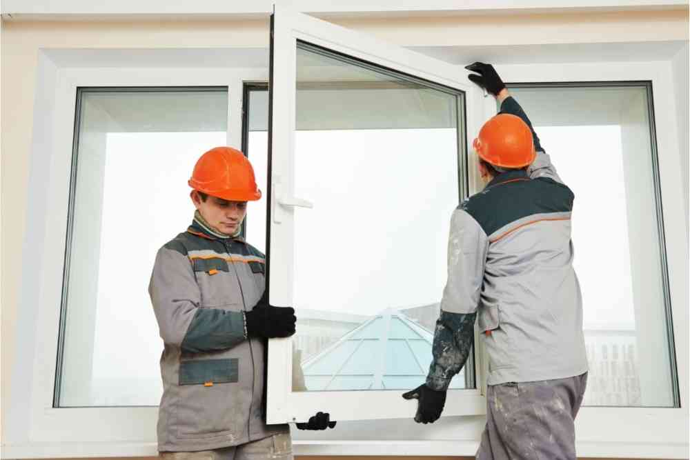 two workers fixing windows